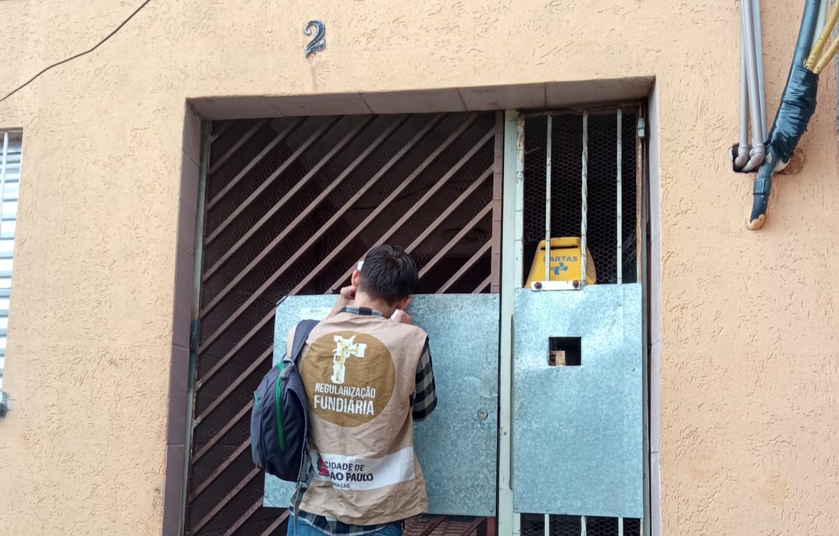 Funcionário da SEHAB atendendo uma casa para realizar os processos do Programa de Regularização Fundiária