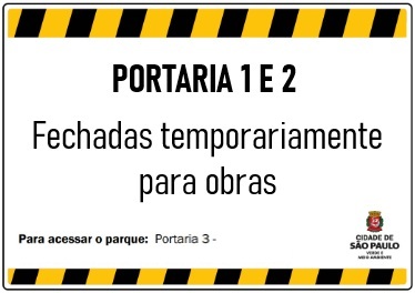 Placa de aviso com borda listrada em preto e amarelo. No centro, em letras grandes e pretas está escrito: PORTARIA 1 E 2 – Fechadas temporariamente para obras.  Na parte inferior, em letras menores: Para acessar o parque: Portaria 3 – Rua Doutor Cândido Motta Filho, 751.  No canto inferior direito há o brasão da Prefeitura de São Paulo com a inscrição:Cidade de São Paulo – Verde e Meio Ambiente