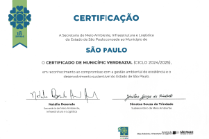 Certificado oficial do Programa Município VerdeAzul, com layout branco e azul, contendo o selo comemorativo de 18 anos no canto esquerdo e os nomes das autoridades assinantes ao final. O texto certifica o Município de São Paulo pelo compromisso com a gestão ambiental.