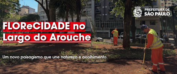 A foto mostra dois trabalhadores da limpeza e manutenção urbana, ambos vestindo uniformes de segurança laranja, coletes refletores e capacetes, trabalhando em uma área aberta de terra batida (possivelmente um canteiro ou jardim em obras) em uma praça. O trabalhador em primeiro plano, à direita, está de costas, curvado e usa um rastelo (ferramenta de jardinagem). O outro trabalhador está mais ao fundo, no centro. Ao redor da área de terra há árvores grandes e, ao fundo, podem ser vistos edifícios urbanos altos e movimentação de rua. A cena remete a um trabalho de revitalização ou paisagismo. Textos no Banner (em branco e vermelho):  Em vermelho e grande destaque, na lateral esquerda: 